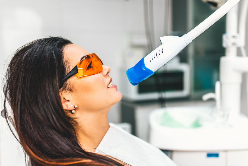 Teeth whitening in dental clinic for pretty female patient Teeth whitening in dental clinic for pretty female patient